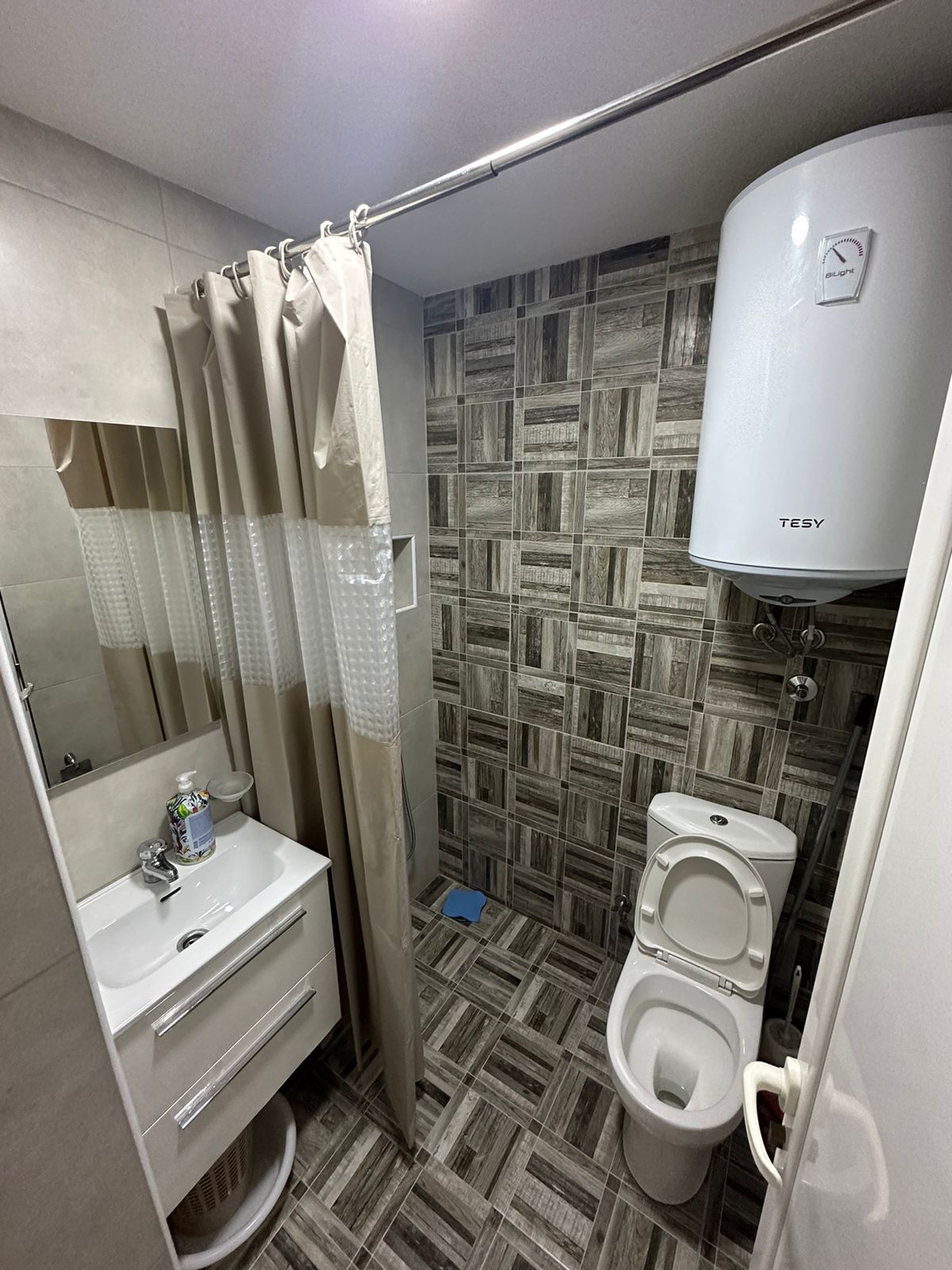 Modern bathroom in Ulcinj real estate by Ekosphere doo, Montenegro: patterned tiles, sink, shower, heater. montenegro-listings.me.