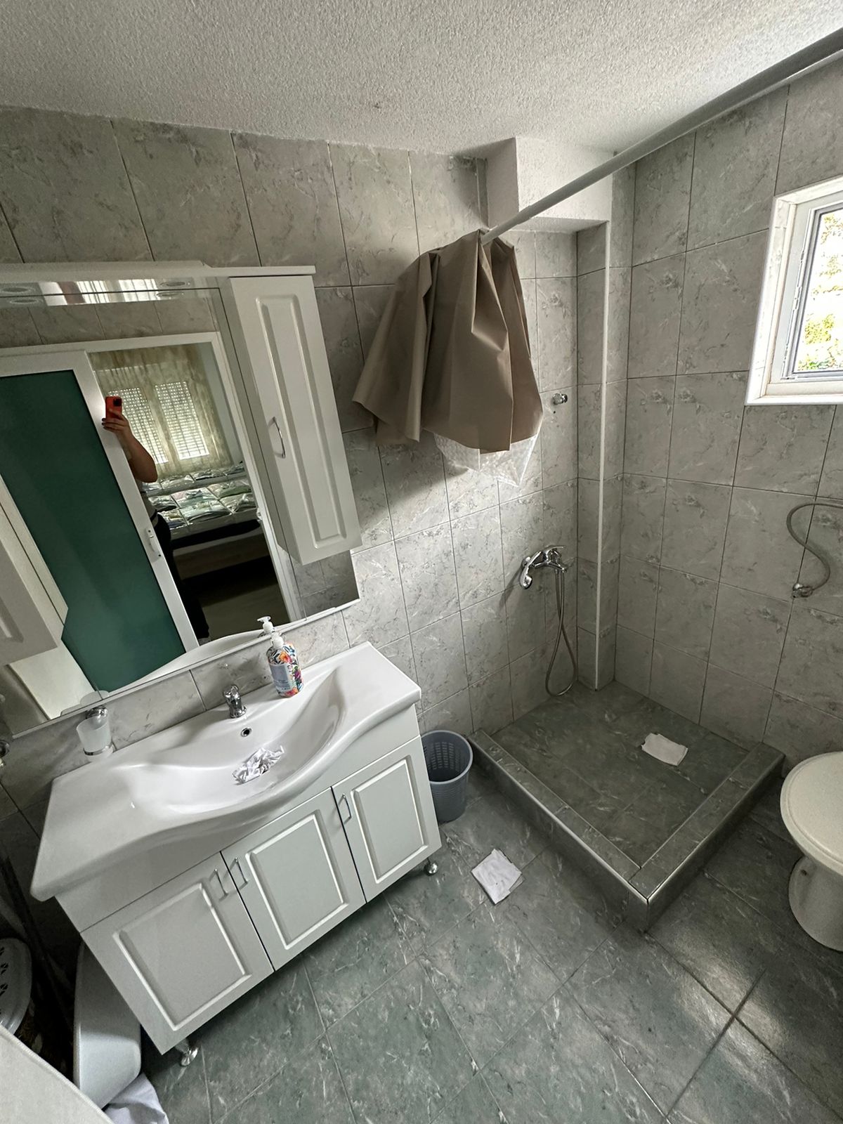 Bright tiled bathroom in Ulcinj with natural light, open shower, modern vanity&mdash;quality investment via montenegro-listings.me by ekosphere doo.