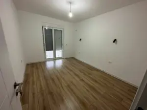 Modern Ulcinj Montenegro property: bright room, wood floors, glass door to outdoors. Featured on montenegro-listings.me by Ekosphere DOO.