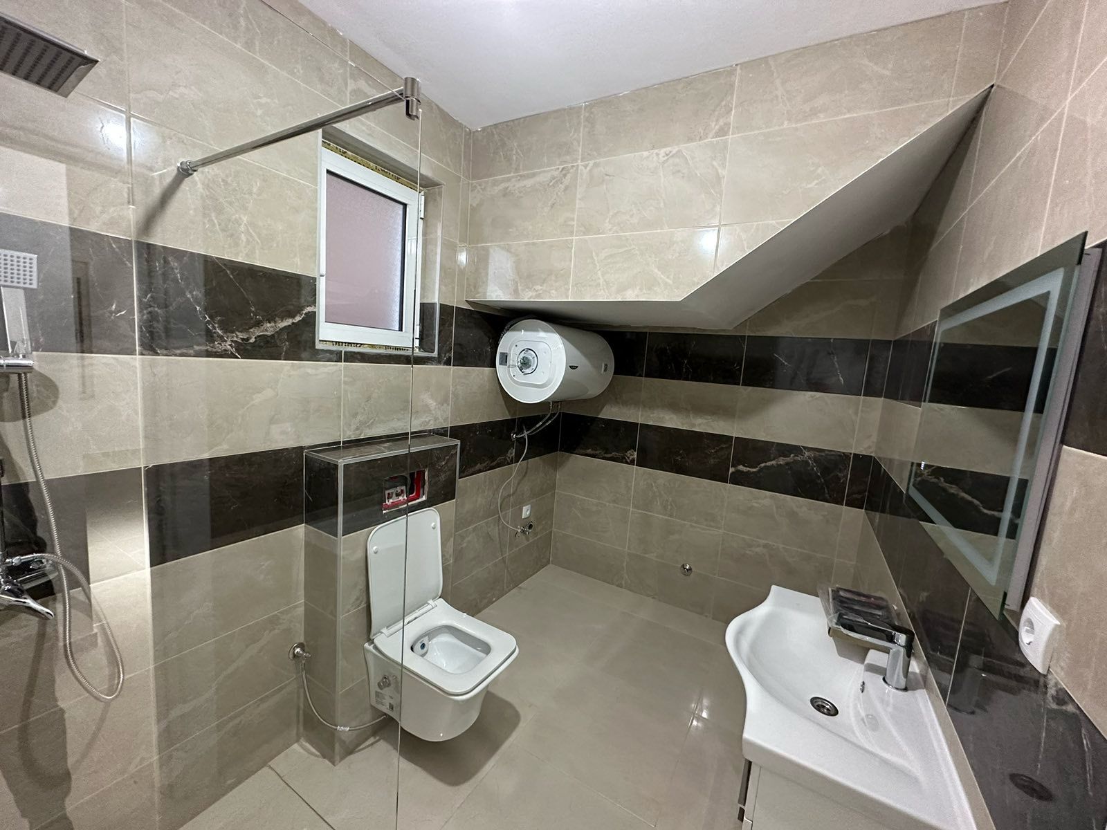 Modern bathroom in Ulcinj property with elegant tiles, glass shower, and premium fixtures. Exclusive on montenegro-listings.me by ekosphere doo.