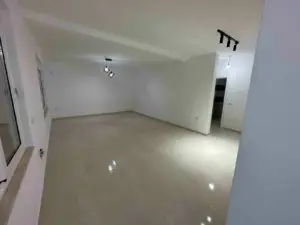 Modern, sunlit room with glossy beige tiles and white walls—prime Ulcinj property for sale on montenegro-listings.me by ekosphere doo.