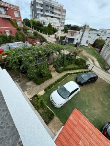 Aerial view of Ulcinj garden plot with pergola, cars, and nearby properties—prime real estate at montenegro-listings.me by Ekosphere.