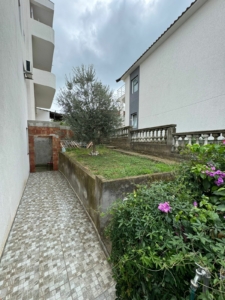 Elegant tiled walkway beside landscaped lawns, lush greenery, and flowers—prime Ulcinj property from ekosphere doo on montenegro-listings.me.