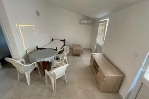 Bright, move-in-ready Ulcinj property: single bed, modern tiled floors, AC, ample seating—ideal investment via montenegro-listings.me by ekosphere doo.