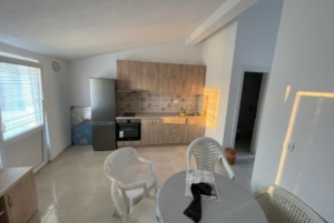 Modern sunlit kitchen in Ulcinj with wood cabinets, stainless appliances, ideal for Montenegro property buyers. Eksophere doo project.