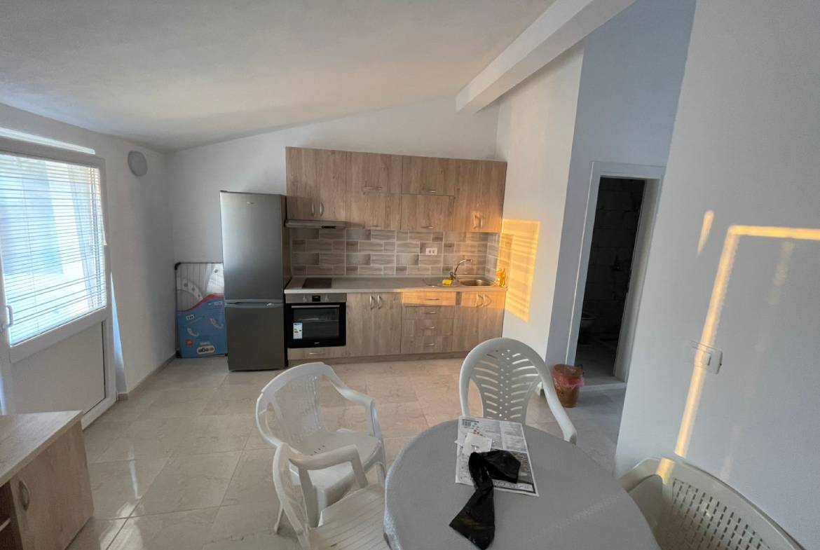 Modern sunlit kitchen in Ulcinj with wood cabinets, stainless appliances, ideal for Montenegro property buyers. Eksophere doo project.