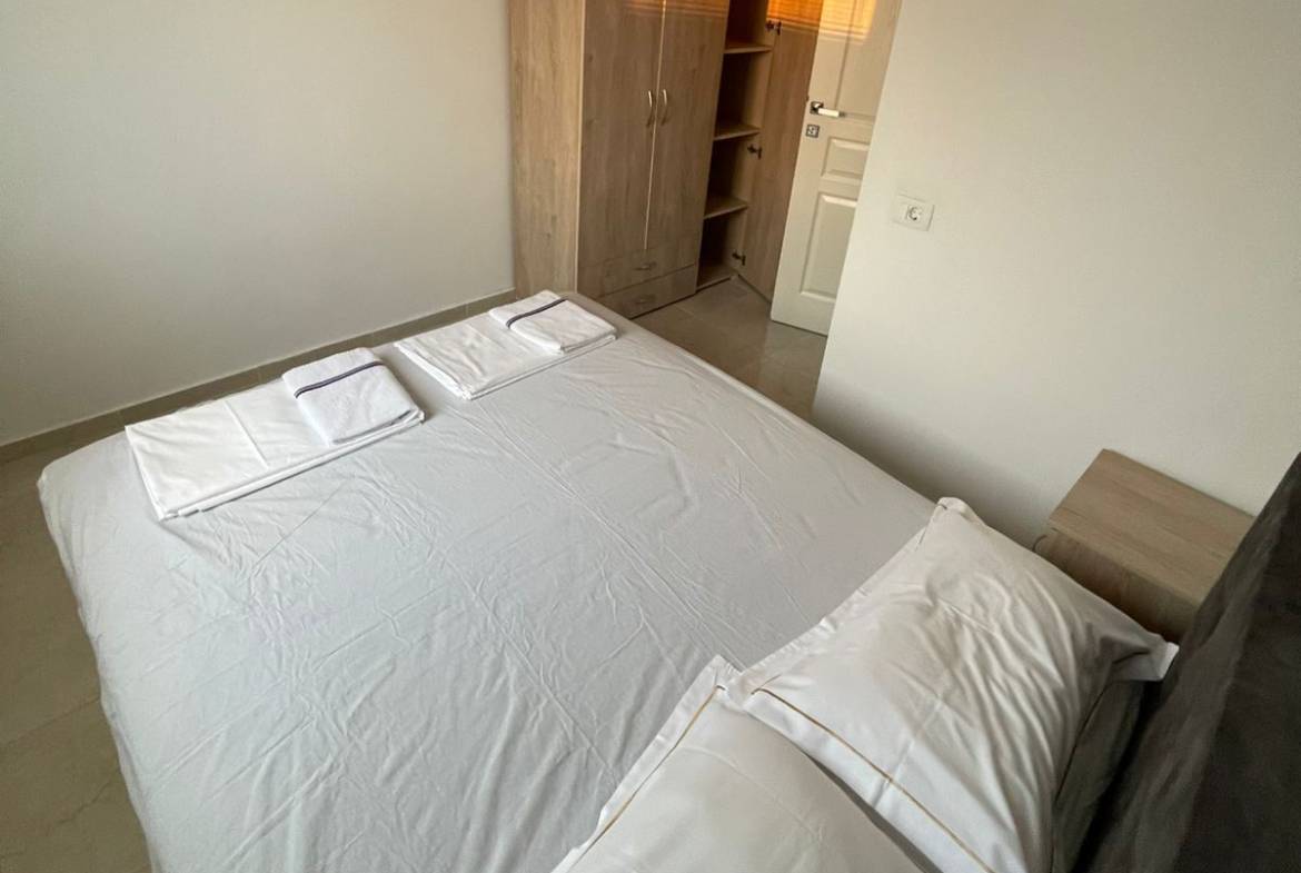 Bright, minimal Ulcinj bedroom with a neat bed, wardrobe, and closet&mdash;exclusive on montenegro-listings.me by ekosphere doo.