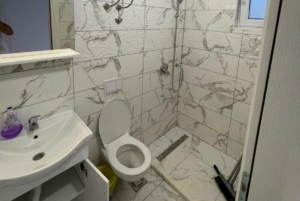 Modern small bathroom in Ulcinj property with marble tiles, walk-in shower; invest via montenegro-listings.me by ekosphere doo.