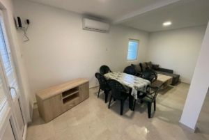 Modern open-plan living/dining in Ulcinj, Montenegro: tiled floors, gray sofa, AC—prime investment at montenegro-listings.me by ekosphere doo.