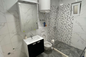 Modern Ulcinj bathroom with marble tile, luxury fixtures, and mosaic shower—prime real estate by montenegro-listings.me (ekosphere doo).