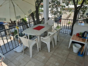 Elegant Ulcinj patio—table, chairs, umbrella, kitchenette—ideal outdoor oasis for property buyers via montenegro-listings.me by ekosphere doo.