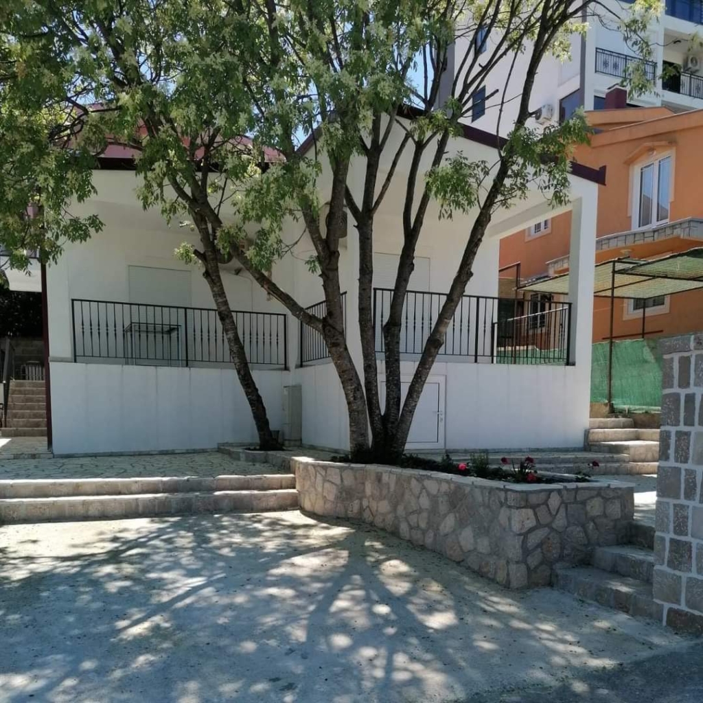 Modern white property with black railings, landscaped stone planter and trees in Ulcinj. Exclusive on montenegro-listings.me by ekosphere doo.
