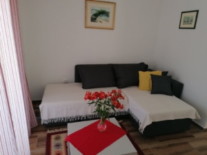Modern Ulcinj living room with gray sectional, vibrant decor, and stylish accents—prime Montenegro real estate at montenegro-listings.me by ekosphere doo.