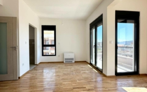 Spacious sunlit room with sleek floors, panoramic balcony views in Ulcinj—prime Montenegro real estate via montenegro-listings.me by ekosphere doo.
