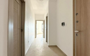 Spacious hallway in Ekosphere DOO Ulcinj property—beige tiles, white walls, wood doors; bright, investment-ready. Montenegro-listings.me.