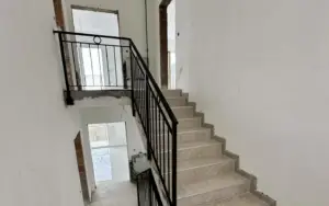 Modern stairway with beige steps and black railing in an Ulcinj property—prime investment from ekosphere doo via montenegro-listings.me.