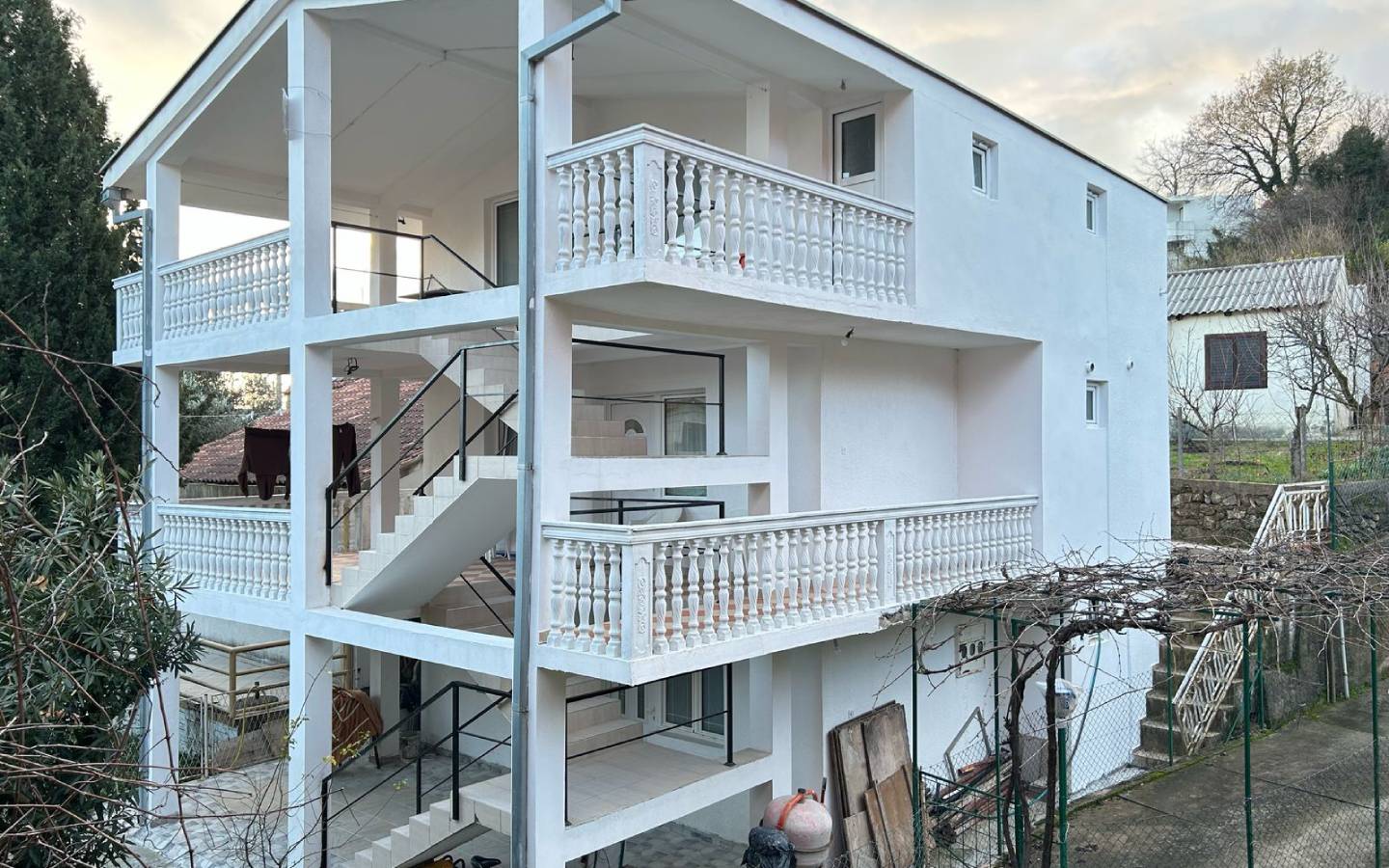 Modern three-story white home in Ulcinj, Montenegro with balconies and lush trees&mdash;exclusive listing on montenegro-listings.me by ekosphere doo.