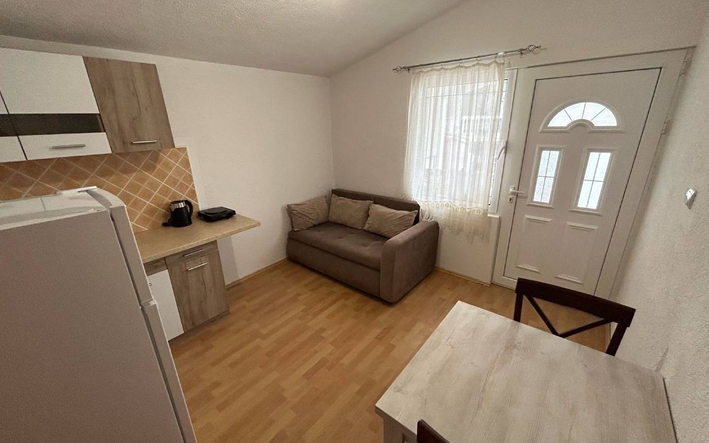 Modern Ulcinj studio with light wood floors, compact kitchen, and cozy furnishings&mdash;prime real estate via montenegro-listings.me by ekosphere doo.