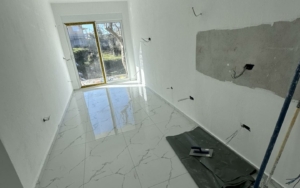 Renovation-ready room in Ulcinj, Montenegro; bright white walls, tiled flooring, glass doors—prime investment at montenegro-listings.me by Ekosphere doo.