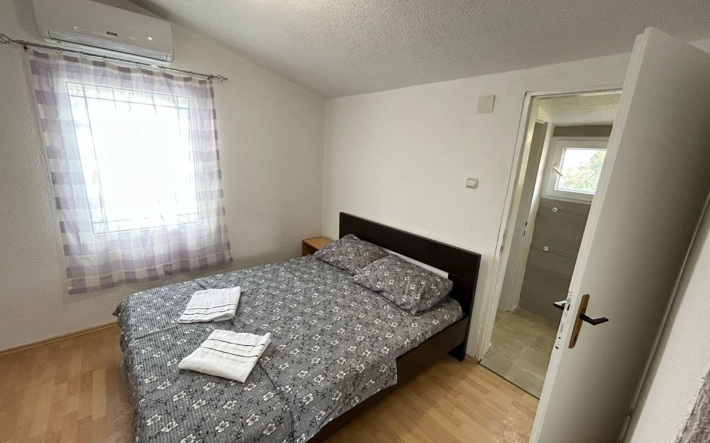 Modern Ulcinj bedroom with double bed, stylish wood floors, ensuite bath; top Montenegro investment on montenegro-listings.me by Ekosphere.