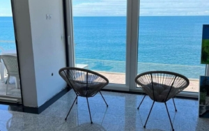 Stunning Ulcinj apartment: panoramic ocean views, elegant wicker seating, tiled floors—exclusive listing from ekosphere doo at montenegro-listings.me.