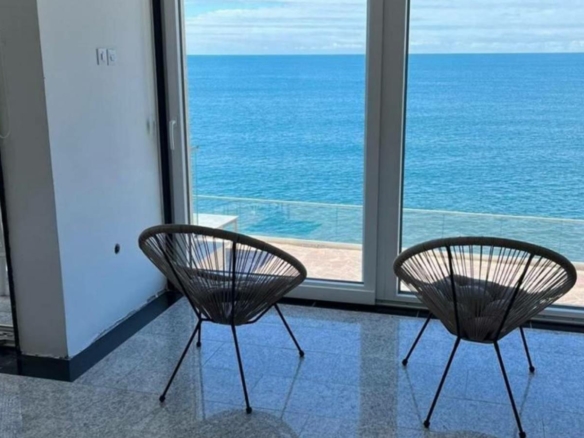 Stunning Ulcinj apartment: panoramic ocean views, elegant wicker seating, tiled floors—exclusive listing from ekosphere doo at montenegro-listings.me.