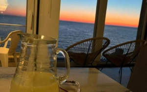 Elegant indoor setting featuring a glass pitcher, with balcony ocean sunset views—ideal Ulcinj investment. montenegro-listings.me by ekosphere doo.