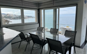 Elegant dining area with glass table, sea views, and modern design in Ulcinj—exclusive real estate from montenegro-listings.me by Ekosphere.