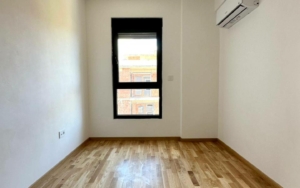 Bright empty room in Ulcinj with wood floors, AC, and natural light—prime real estate from montenegro-listings.me by Ekosphere doo.
