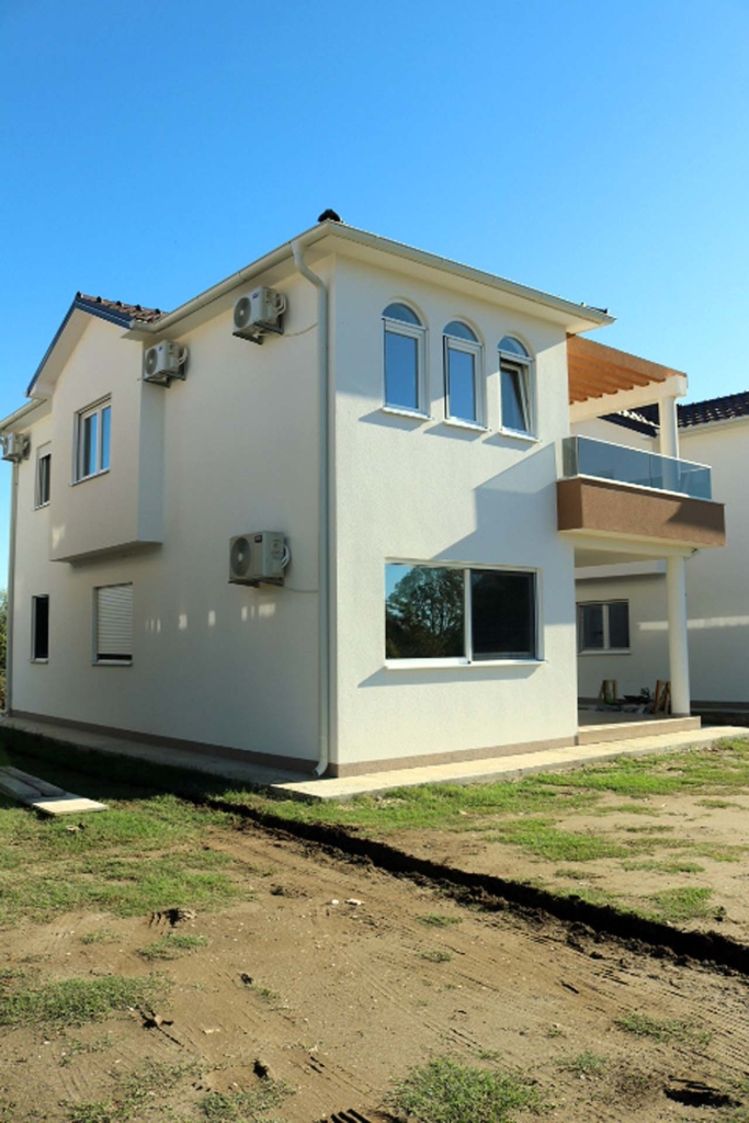 Elegant modern two-story villa in Ulcinj, Montenegro with white facade, glass balcony, A/C units; exclusive at montenegro-listings.me by ekosphere doo.