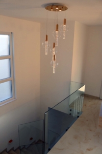 Elegant staircase with glass railings, beige floors, and natural light—luxury Ulcinj villa listed on montenegro-listings.me by ekosphere doo.