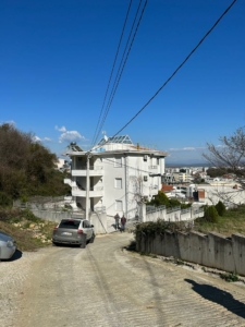 White multi-story property in Ulcinj, Montenegro on a quiet road—prime real estate investment by ekosphere doo for montenegro-listings.me.