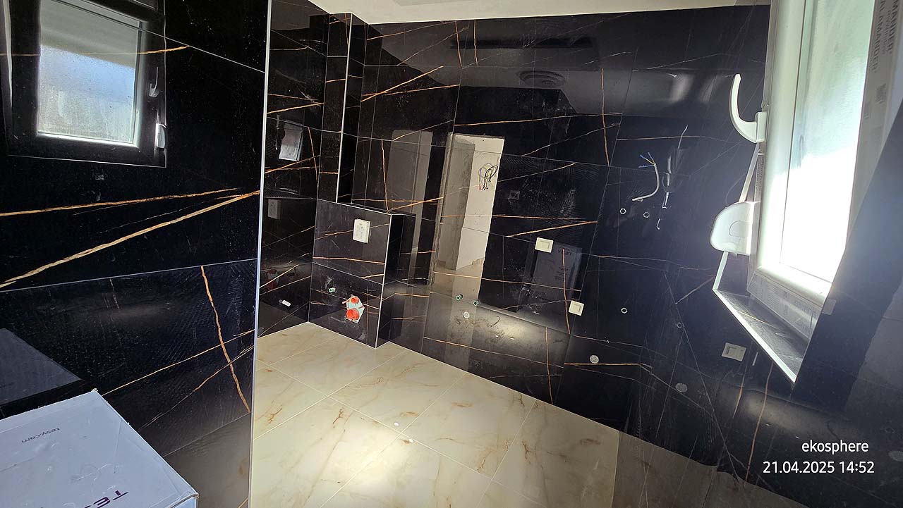 Modern bathroom in Ulcinj, Montenegro&mdash;black orange-streaked walls, beige tiles, sunlit window. Exclusive on montenegro-listings.me by ekosphere doo.