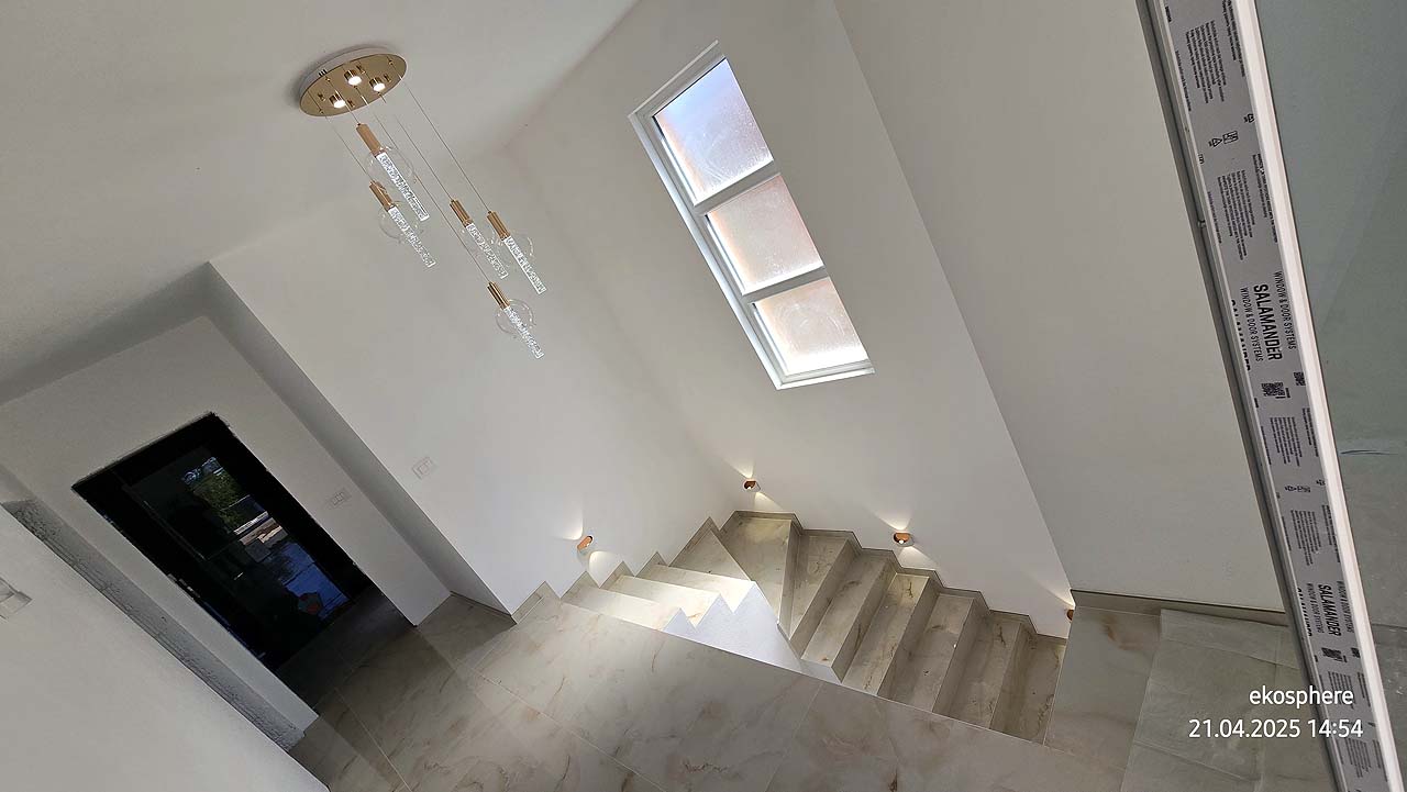 Elegant staircase with beige steps, chic lights, and tall window&mdash;ideal Ulcinj investment, listed by montenegro-listings.me (ekosphere doo).
