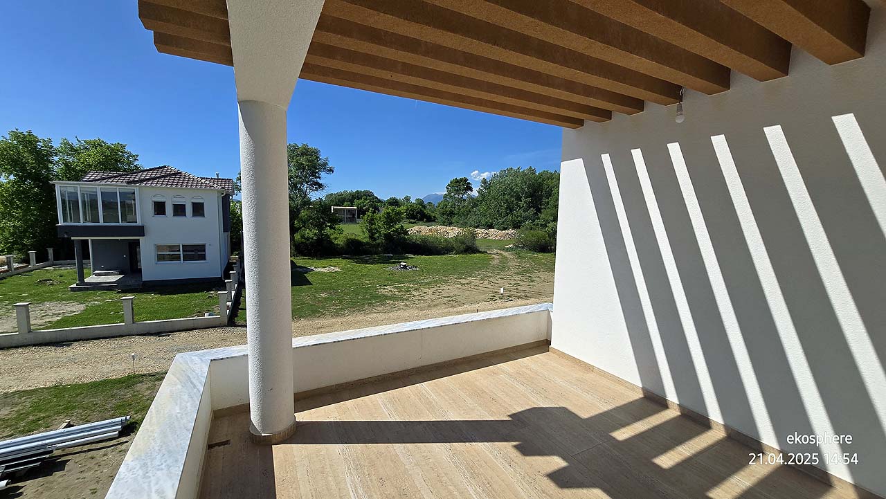 Bright covered balcony with wooden beams, lush yard, and modern home&mdash;prime Ulcinj real estate from montenegro-listings.me/Ekosphere doo.