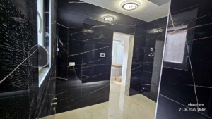 Contemporary room with black marble walls, window, and doorway to bright space. Prime Ulcinj real estate—montenegro-listings.me by ekosphere doo.