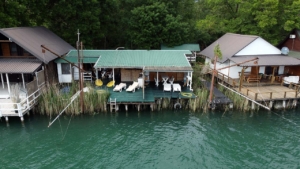 Stylish riverside deck with white seating, lush greenery, and eco-inspired buildings—premier Ulcinj real estate via ekosphere doo.