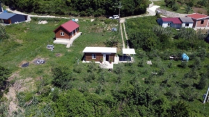 Aerial view of eco-friendly Ulcinj property: 2 wooden homes, outbuildings, lush land. Invest via montenegro-listings.me by Ekosphere doo.
