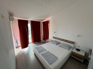 Modern hotel room in Ulcinj, Montenegro, with double bed, wood floors—ideal real estate investment by ekosphere doo via montenegro-listings.me.