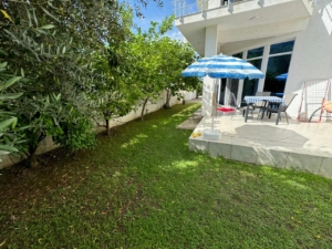 Charming Ulcinj home: lush backyard, patio, trees, and white house. Prime real estate by ekosphere doo on montenegro-listings.me.