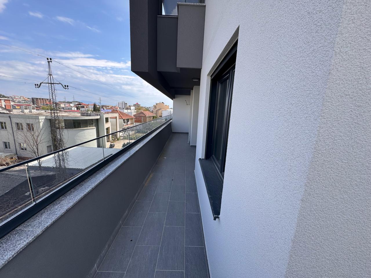 Modern balcony with glass railing and gray tiles, prime Ulcinj real estate; great views&mdash;exclusive on montenegro-listings.me by ekosphere doo.