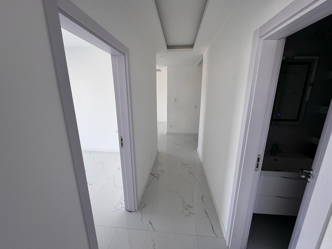 Modern hallway in eksosphere-designed Ulcinj property with marble floors, white walls, 2 rooms. Exclusive on montenegro-listings.me.