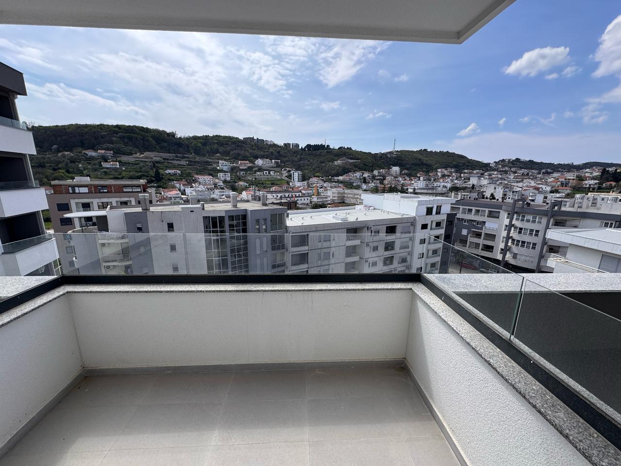 Stunning balcony view with glass railing over modern Ulcinj apartments, scenic hills—exclusive property at montenegro-listings.me by ekosphere doo.