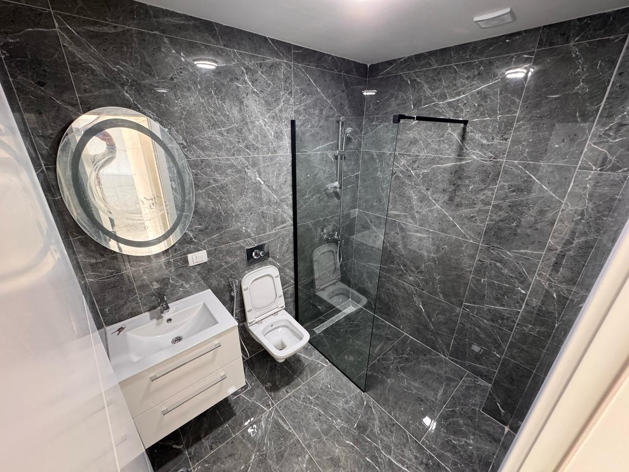 Luxurious Ulcinj property: elegant bathroom with marble, walk-in shower, and chic vanity&mdash;montenegro-listings.me by Ekosphere DOO.