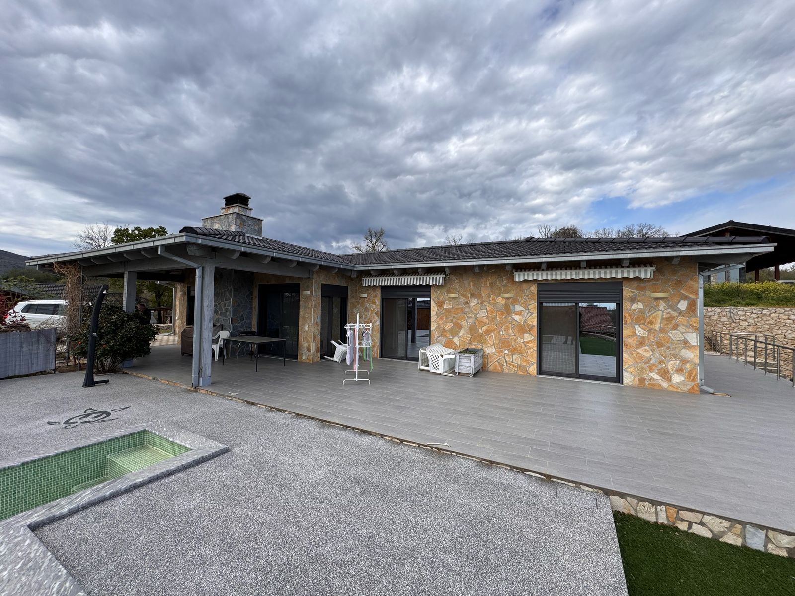 Stunning modern villa in Ulcinj, Montenegro—stone & stucco, elegant patio, tiled deck by pool. Exclusive at montenegro-listings.me by ekosphere doo.