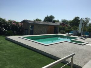 Modern rectangular pool, concrete deck, lounge chairs, pool house—luxury Ulcinj real estate by montenegro-listings.me/ekosphere doo.