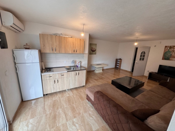 Stunning Ulcinj apartment: tiled floors, modern kitchen, spacious brown sectional—top investment via montenegro-listings.me by ekosphere doo.