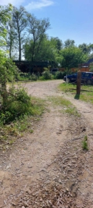 Prime Ulcinj property: sunlit land with parking, lush greenery, and building access—ideal investment via montenegro-listings.me by ekosphere doo.