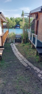 Charming Ulcinj riverfront real estate with stone path, dock, and scenic views—ideal property investment via montenegro-listings.me by ekosphere doo.