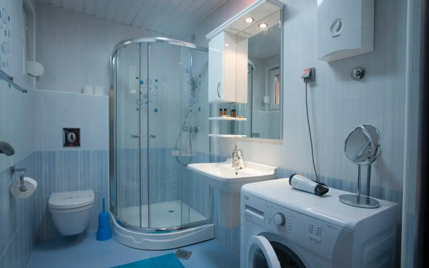 Contemporary Ulcinj bathroom: glass shower, modern fixtures, washing machine. Invest in Montenegro with montenegro-listings.me by ekosphere doo.